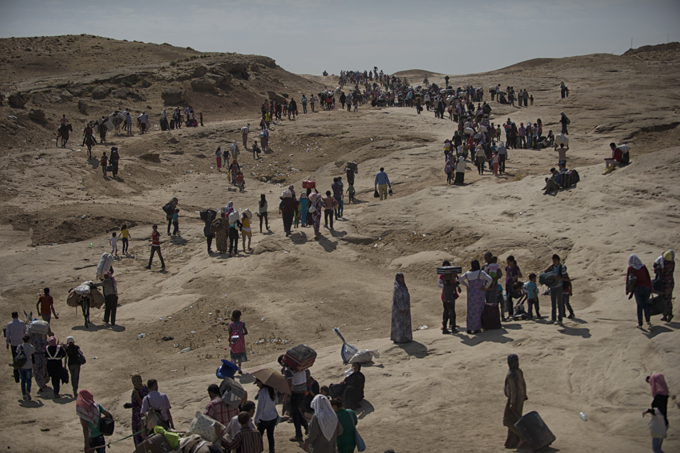 Thousands of Syrian refugees cross from Syria into the Kurdish region of northern Iraq near the Peshkhabour border point in Dohuk, Iraq. Iraqi Kurdistan has welcomed Syrian refugees, particularly those of Kurdish background, since the beginning of the conflict in 2011. Photo by Lynsey Addario, August 21, 2013.