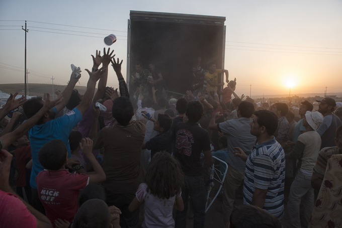 Syrian refugees clamor for clothes and other items being distributed by Kurdish people at the Karkos camp outside of Erbil, in northern Iraq. Photo by Lynsey Addario, August 20, 2013.